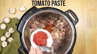 Adding the tomato paste to the Instant Pot 