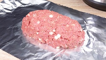 Ground beef meatloaf being wrapped in foil