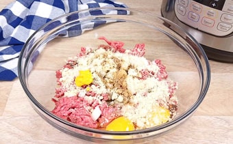 Ground beef, seasonings and raw egg in a mixing bowl to make the meatloaf