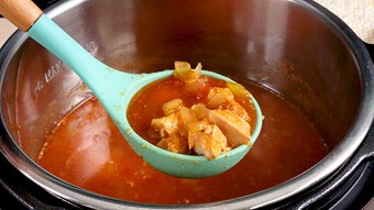 Chicken taco soup being served with a blue ladle