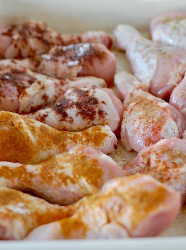 Raw chicken drumsticks covered in various spices 