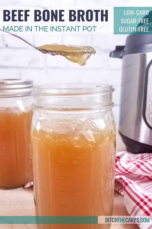 Beef bone broth being spooned out from a glass jar sitting in front of an Instant Pot