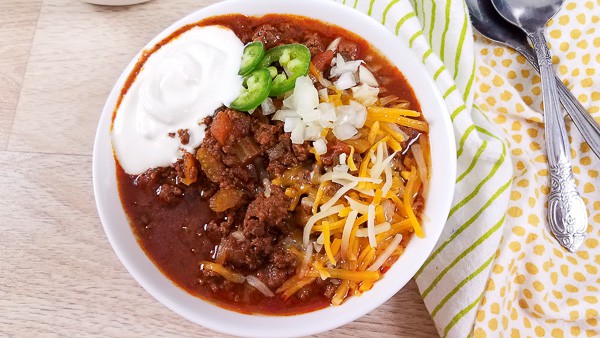A bowl of keto chilli served with sour cream and jalapenos