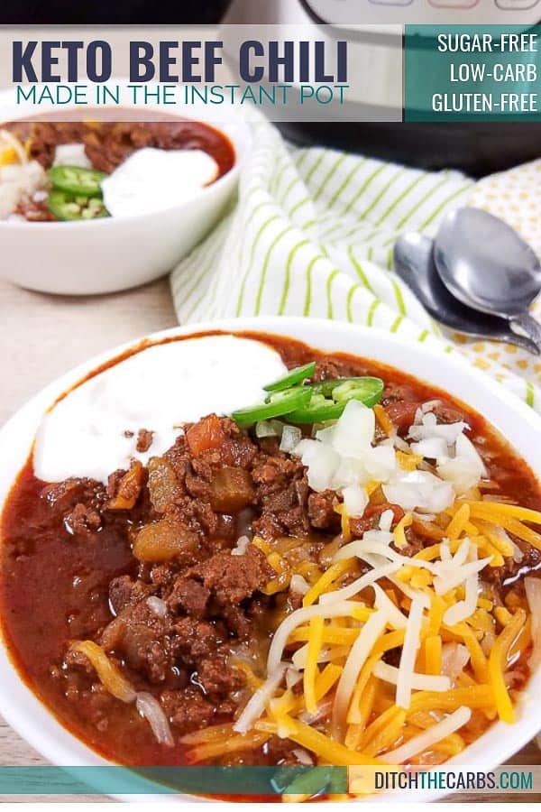 A bowl of keto chili served with sour cream and shredded cheese