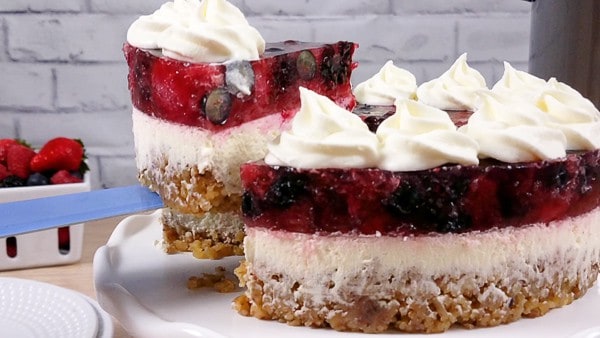 A slice of berry cheesecake being lifted and served