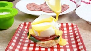 hollandaise sauce being poured over poached eggs and keto muffins