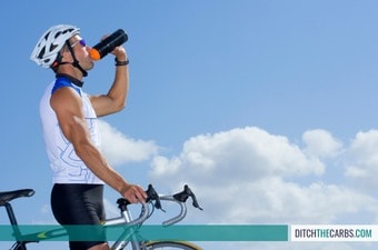 A male cyclist drinking from a water bottle