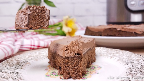 Low-carb Instant Pot chocolate cake sliced and served and showing the instant pot in the background
