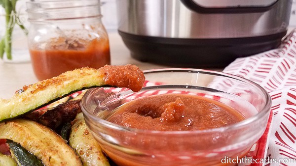 Dipping cooked vegetables into a bowl of sugar free ketchup