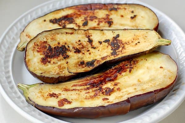 Cooked eggplant from the frying pan about to be filled with cauliflower couscous