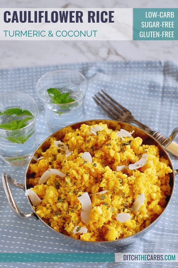 A bowl of curried cauliflower rice with water and antique cutlery
