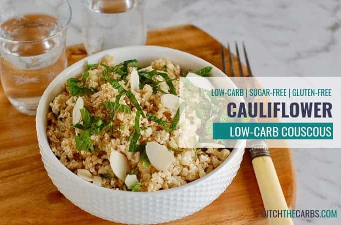 A bowl of cauliflower couscous the wooden board with an antique fork