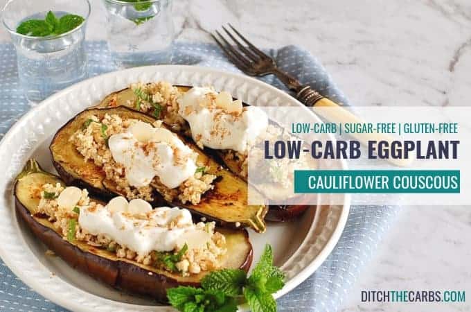 Three baked eggplant on a plate filled with cauliflower couscous and sour cream topped with spices