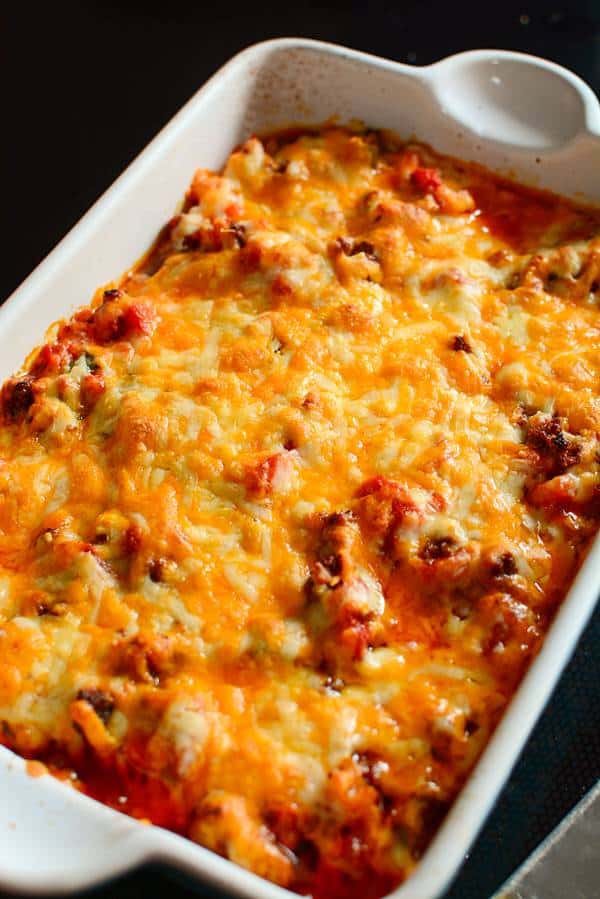 A baking dish filled with cooked keto chili topped with a crusty cheese topping