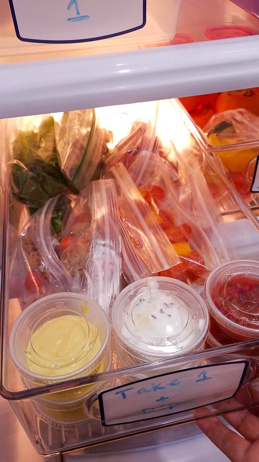 A plastic container filled with low-carb lunchbox food and ziplock bags