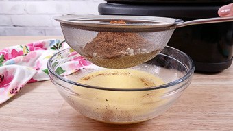 Sifting cocoa powder into the mixing bowl with eggs