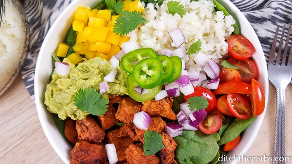 A burrito bowl with colourful vegetables and salad