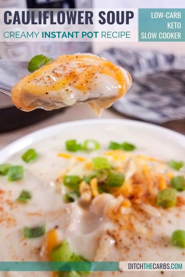 Creamy cauliflower soup being served with shredded cheese