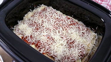 Slow cooker dish with layers of zucchini and tomato sauce with cheese