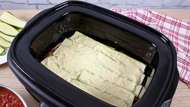 Slow cooker dish with layers of zucchini and cheat\'s cheese sauce
