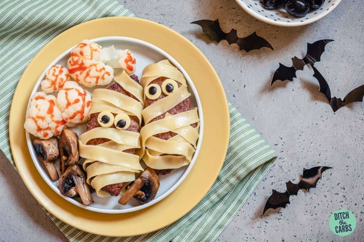 sausages decorated to look like spooky mummies