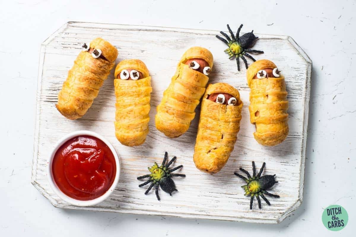 sausages decorated to look like spooky mummies