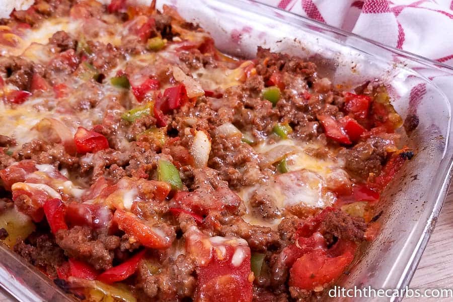 Cooked ground beef covered in cheese and a glass baking dish