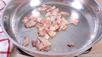 Pieces of bacon being fried