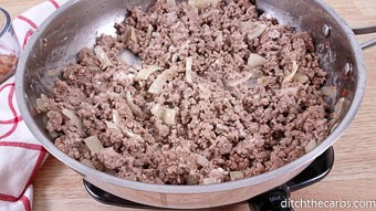 A frying pan with cooked ground beef and onions