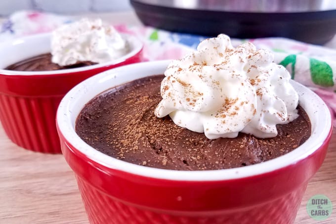 red ramekin containing chocolate mousse and whipped cream