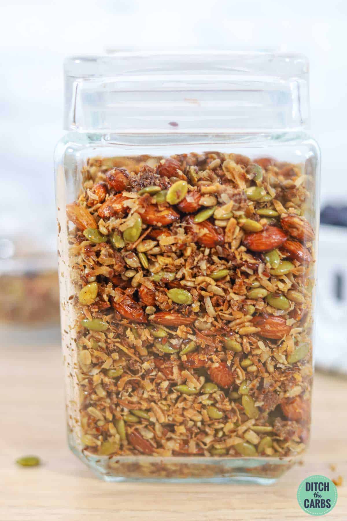 a square storage jar with keto granola inside