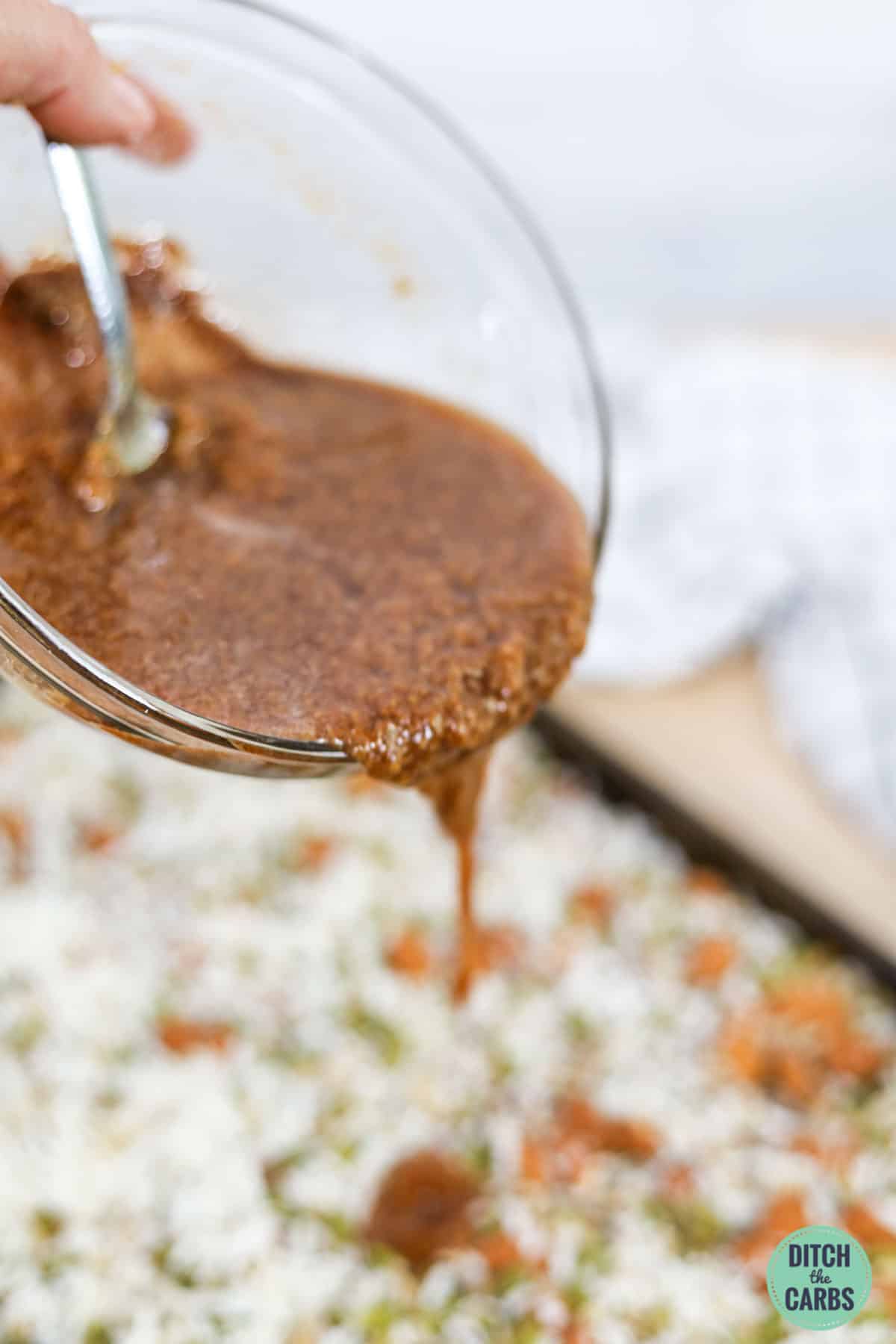 pouring sugar-free cinnamon sauce over keto cereal