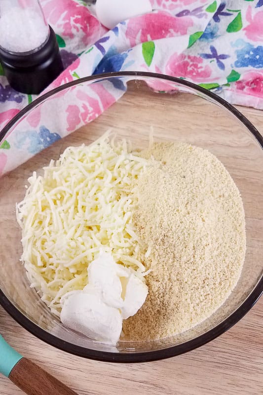 A bowl of shredded cheese, almond flour and cream cheese