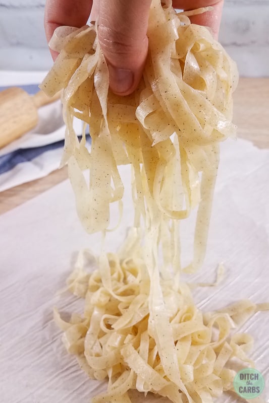 hands holding pasta to separate