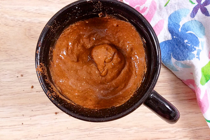 Mixed batter for double chocolate low-carb mug cake in a black mug.