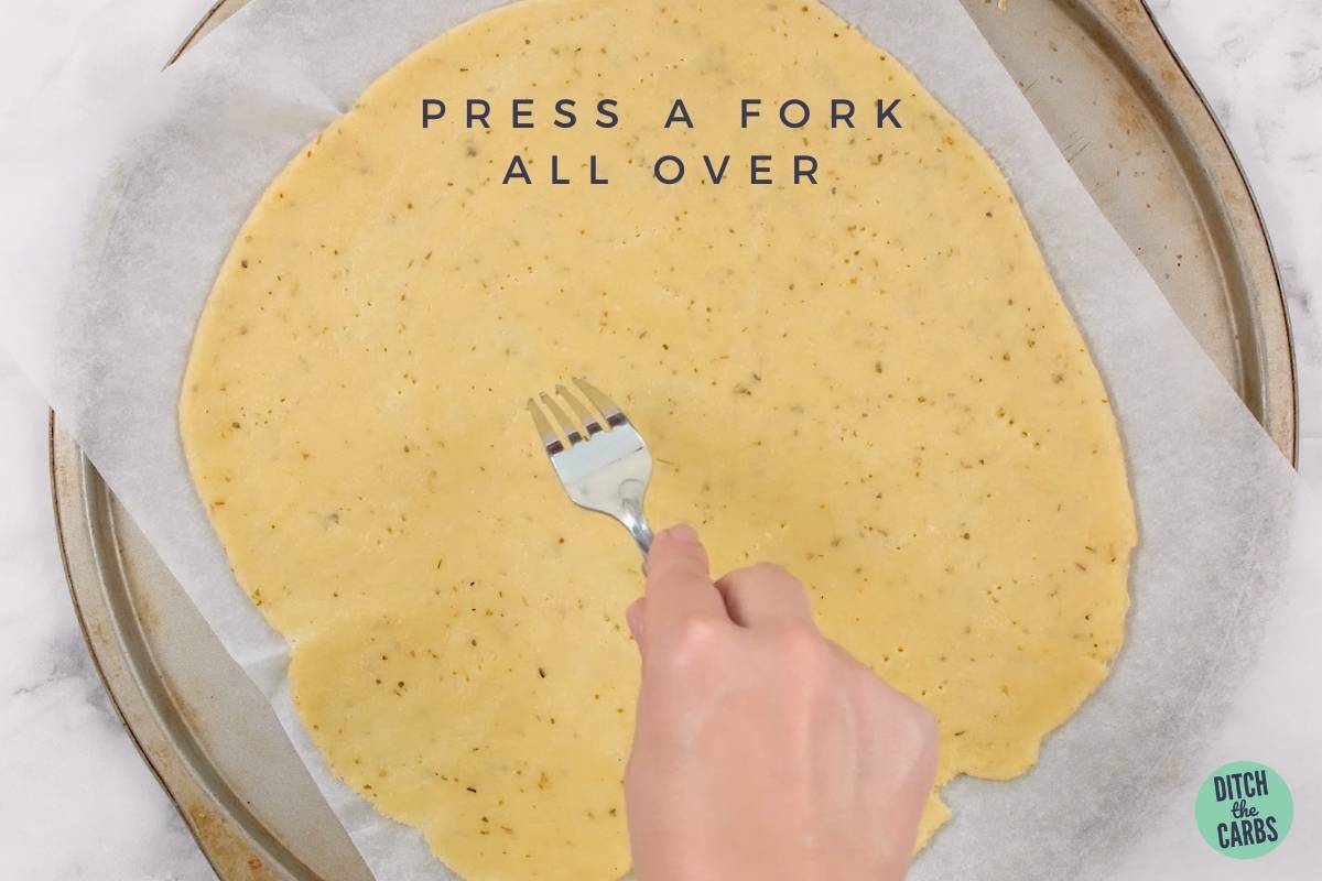 pressing a fork all over the pizza base