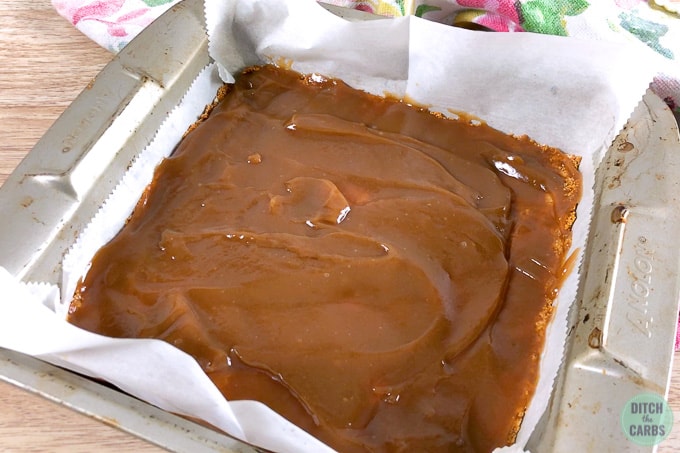 Caramel spread over the almond flour crust in a square baking pan. Ready to chill in the refrigerator.