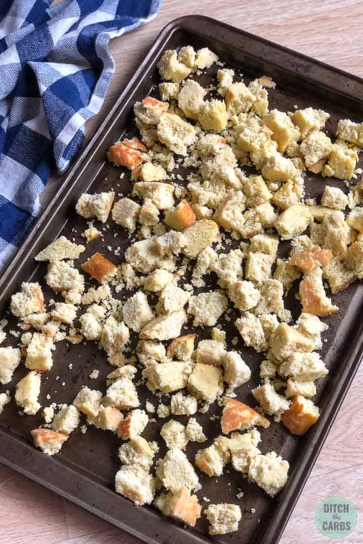 Keto cornbread broken into bite sized pieces and spread over a large baking sheet.