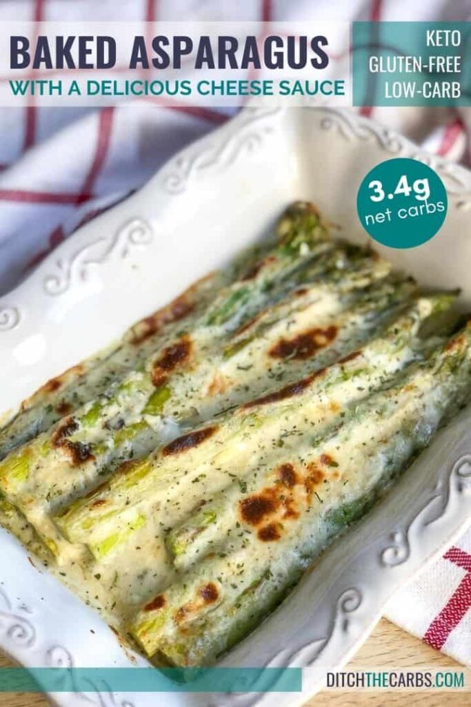 Keto cheesy baked asparagus in a white baking pan.