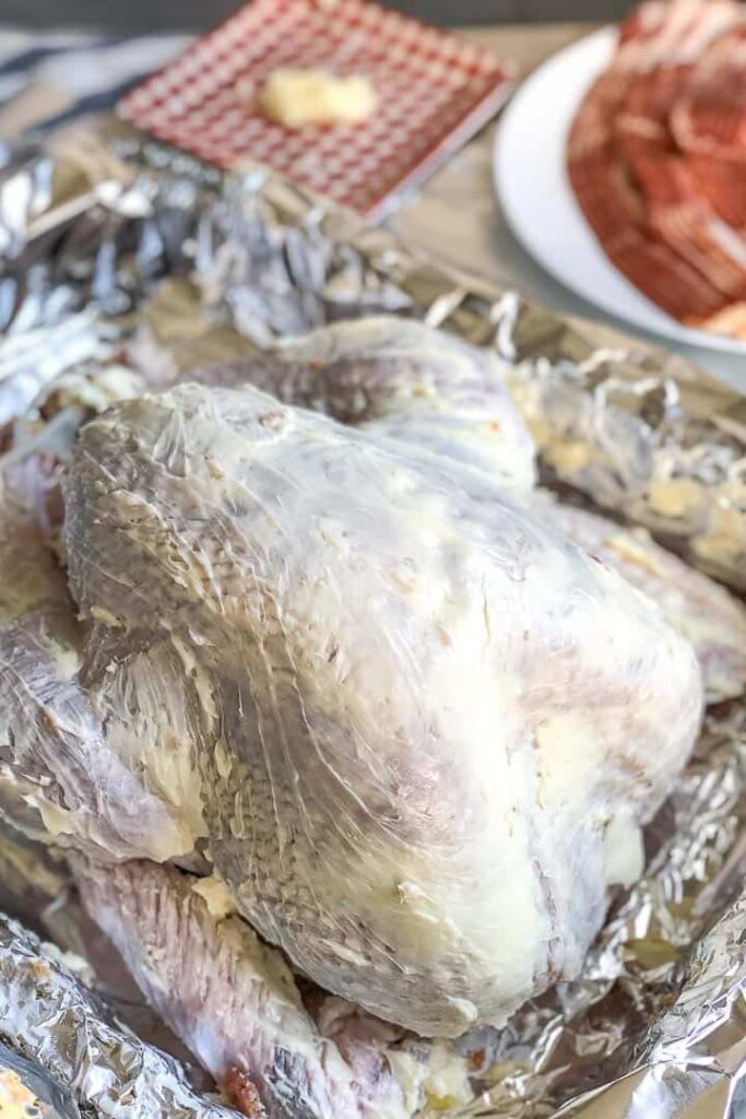 A turkey covered in butter about to be roasted