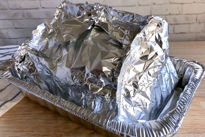 A turkey covered in aluminium foil ready to roast