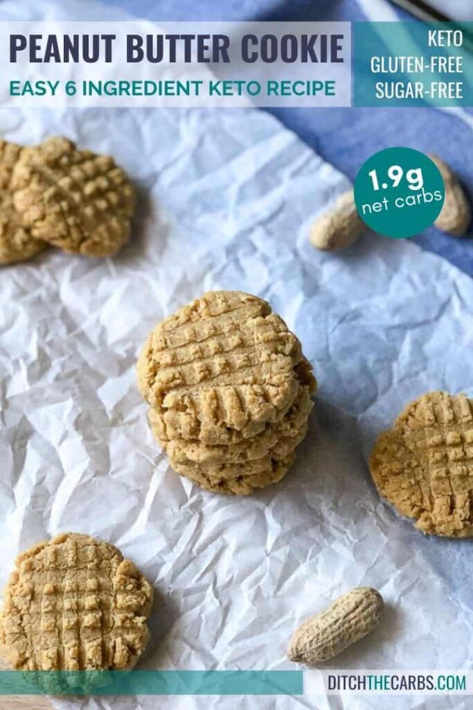 Keto peanut butter biscuits stacked on a sheet of white parchment.
