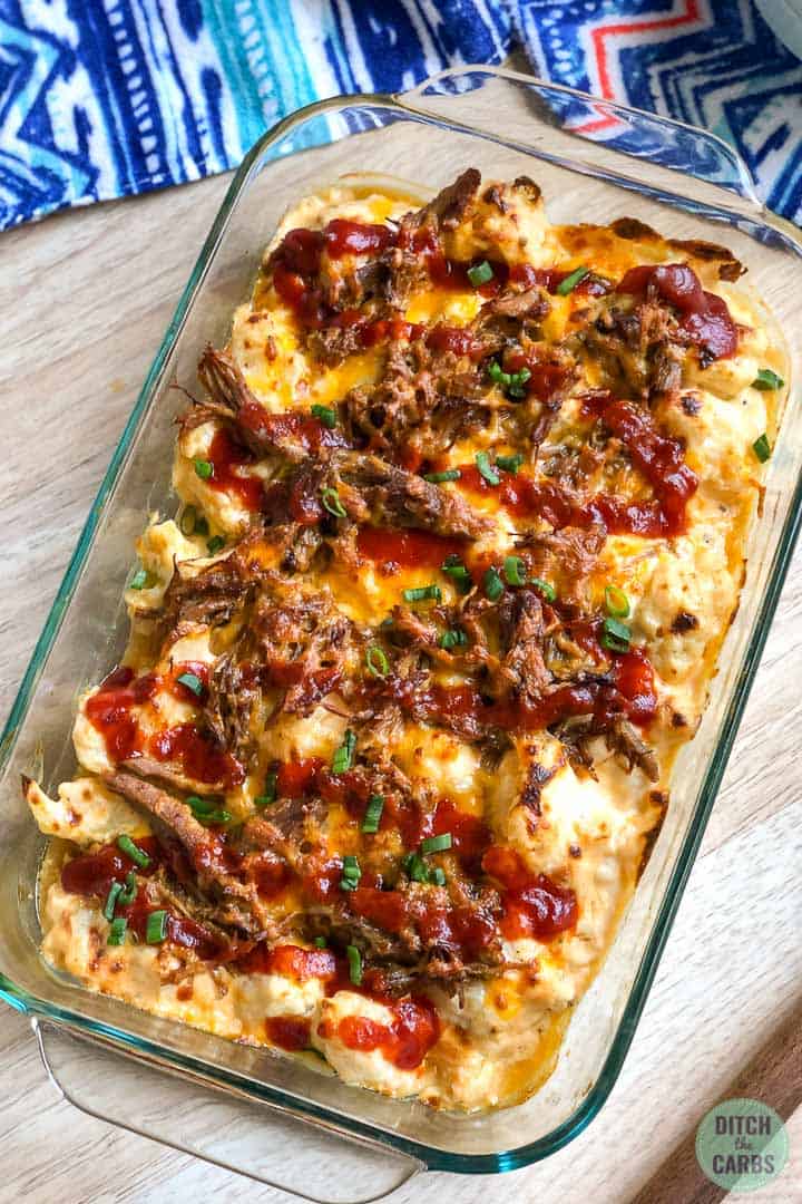 A clear glass casserole pan of keto pulled pork mac and cheese cooling on the counter 