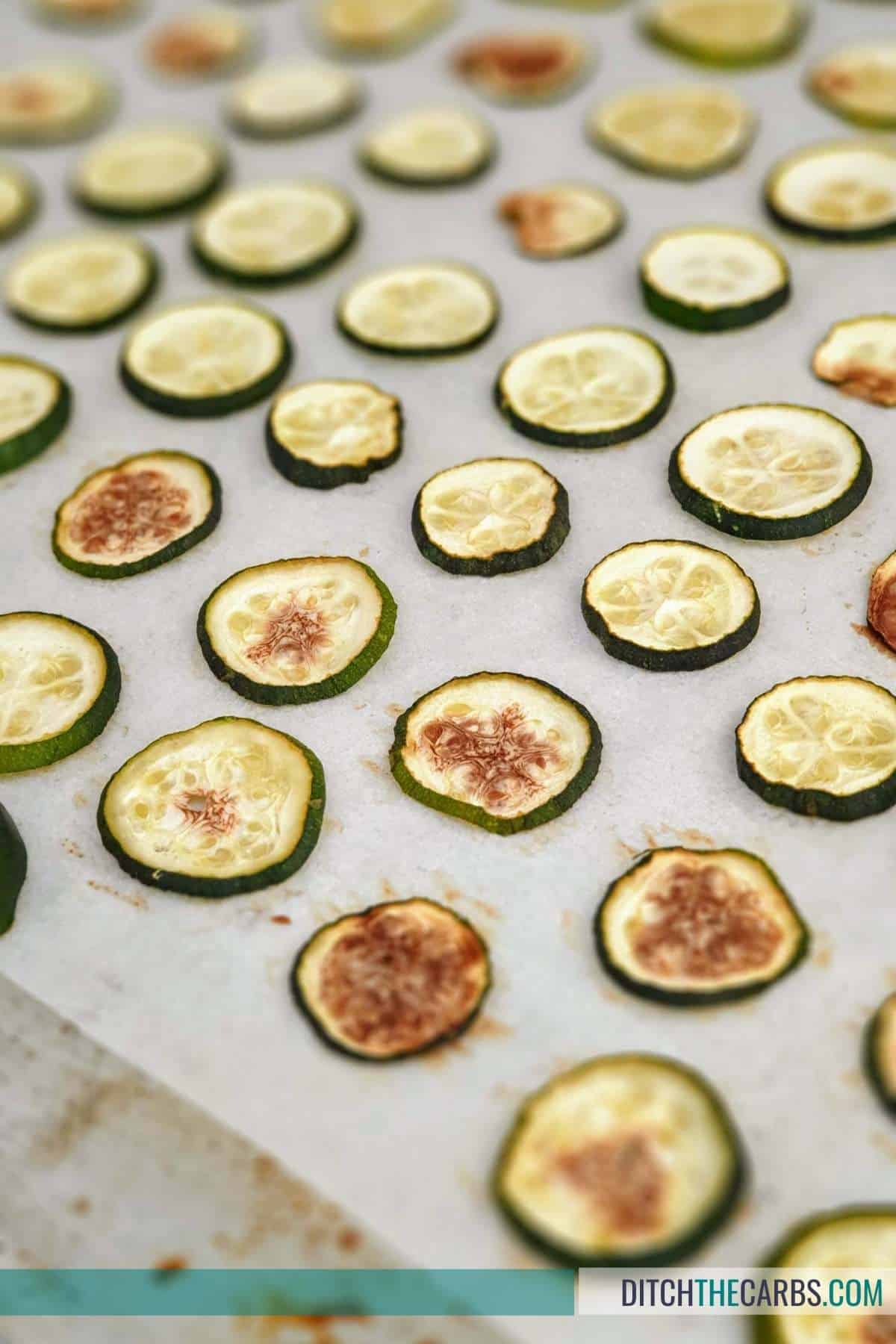 sliced zucchini on a lined baking tray