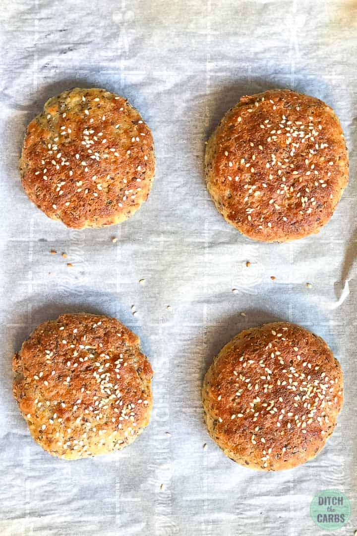 Overhead shot of baked keto hamburger buns on a baking sheet covered with parchment paper. 
