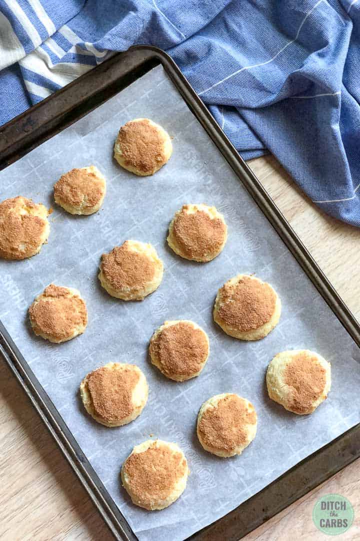 Keto snickerdoodle cookies cooling on the cookies sheet on the counter.