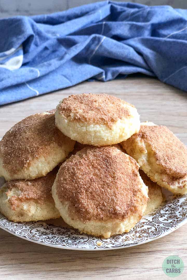 Cooked snickerdoodle cookies piles high on a plate. 