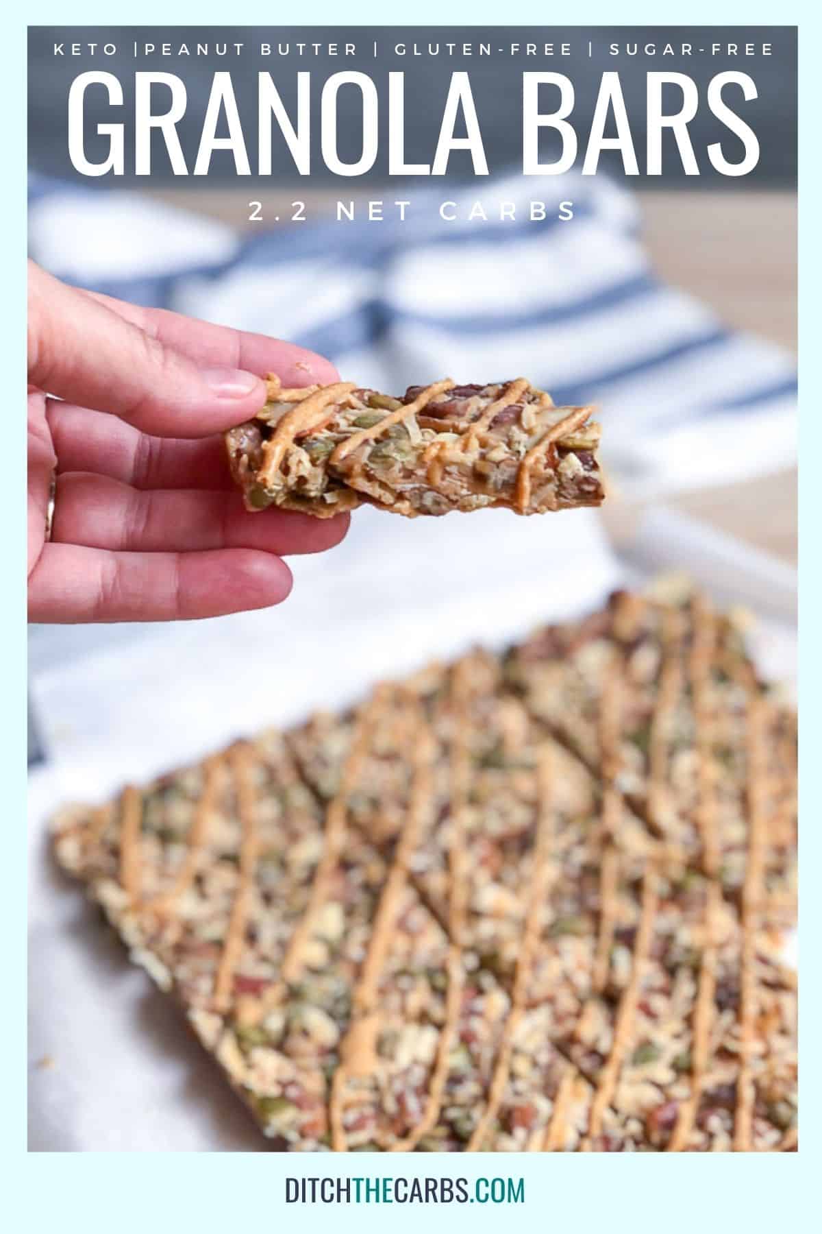 A hand is lifting one keto peanut butter granola bar from the rest of the granola bars resting on the counter.