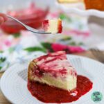 a slice of keto raspberry cheesecake on a white plate and a silver fork