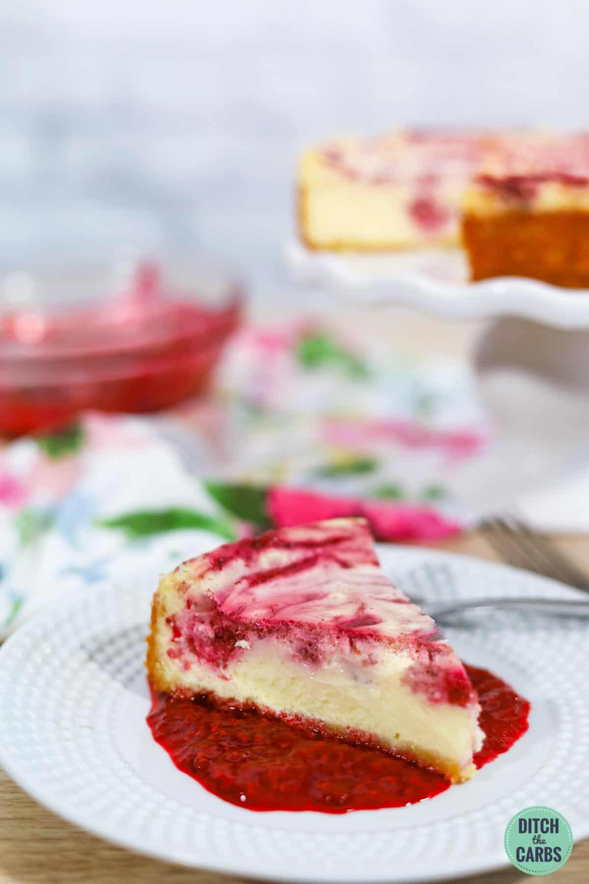 a slice of keto raspberry cheesecake on a white plate